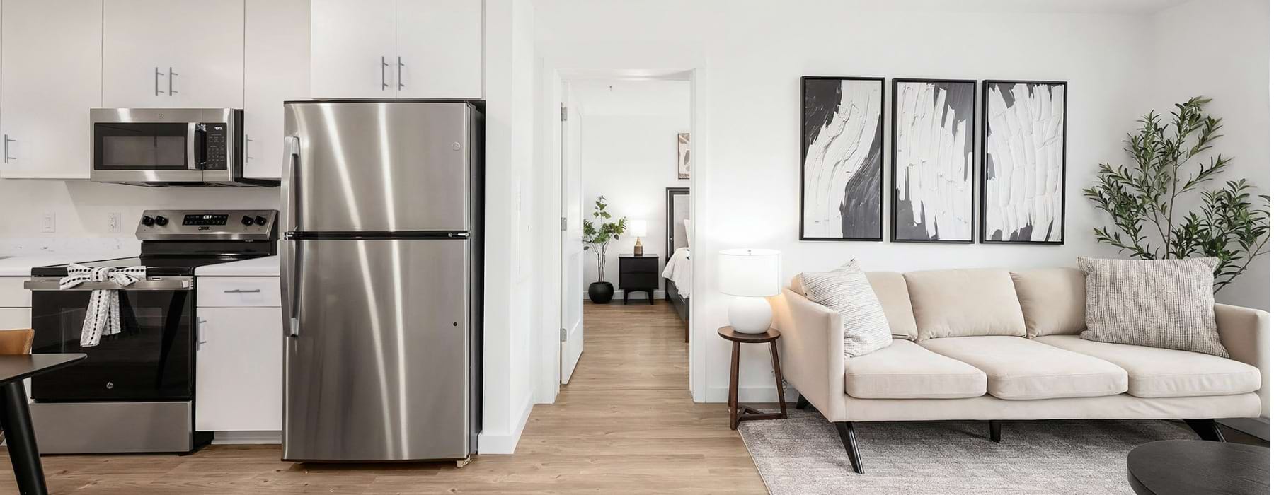 A spacious floor plan with ample light, wood-style flooring and white cabinets at The Randall Woodbury, NJ apartments for rent.